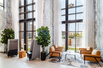 A lobby with couches and chairs and large windows